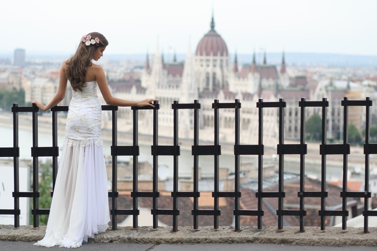 Photo by: Daci - Take a stroll around the sweeping views of Budapest and you will find yourself surrounded by pointed beauty. By using the concrete lines of this harsh fencing, the delicate lace sewn onto the bride’s gown and blush pink and satin white flowers garnishing her sweeping locks dazzle.