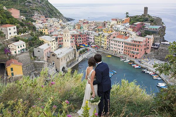 Photo by: Lauren Michelle - These candy-store colors provide the perfect backdrop to make your pictures pop! Having the bride and groom stand in the forefront of the photo gives them heed over this ebullient, little Italian town.